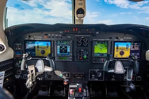 The aircraft cockpit features a modern glass panel with multiple digital displays and dual yokes.
