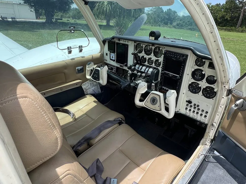 The cockpit of the aircraft features tan leather seats and a detailed instrument panel with modern displays.