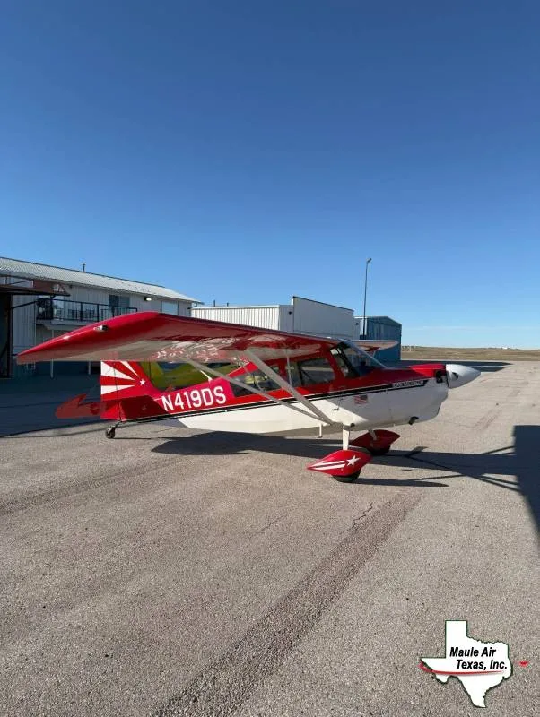 A red and white Maule M-7-235B aircraft with tail number N419DS parked on an asphalt tarmac under a clear blue sky.
