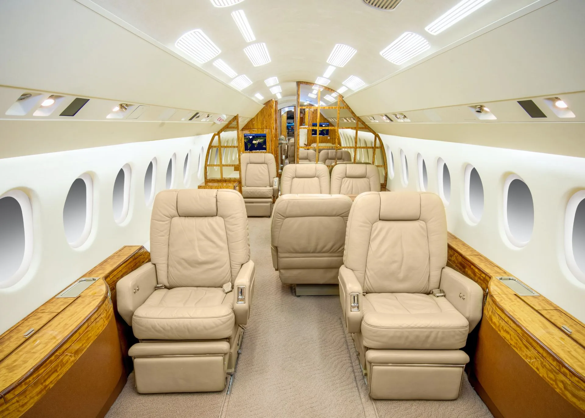 A slightly different angle of the aircraft's main cabin, featuring beige leather seating and wood accents.
