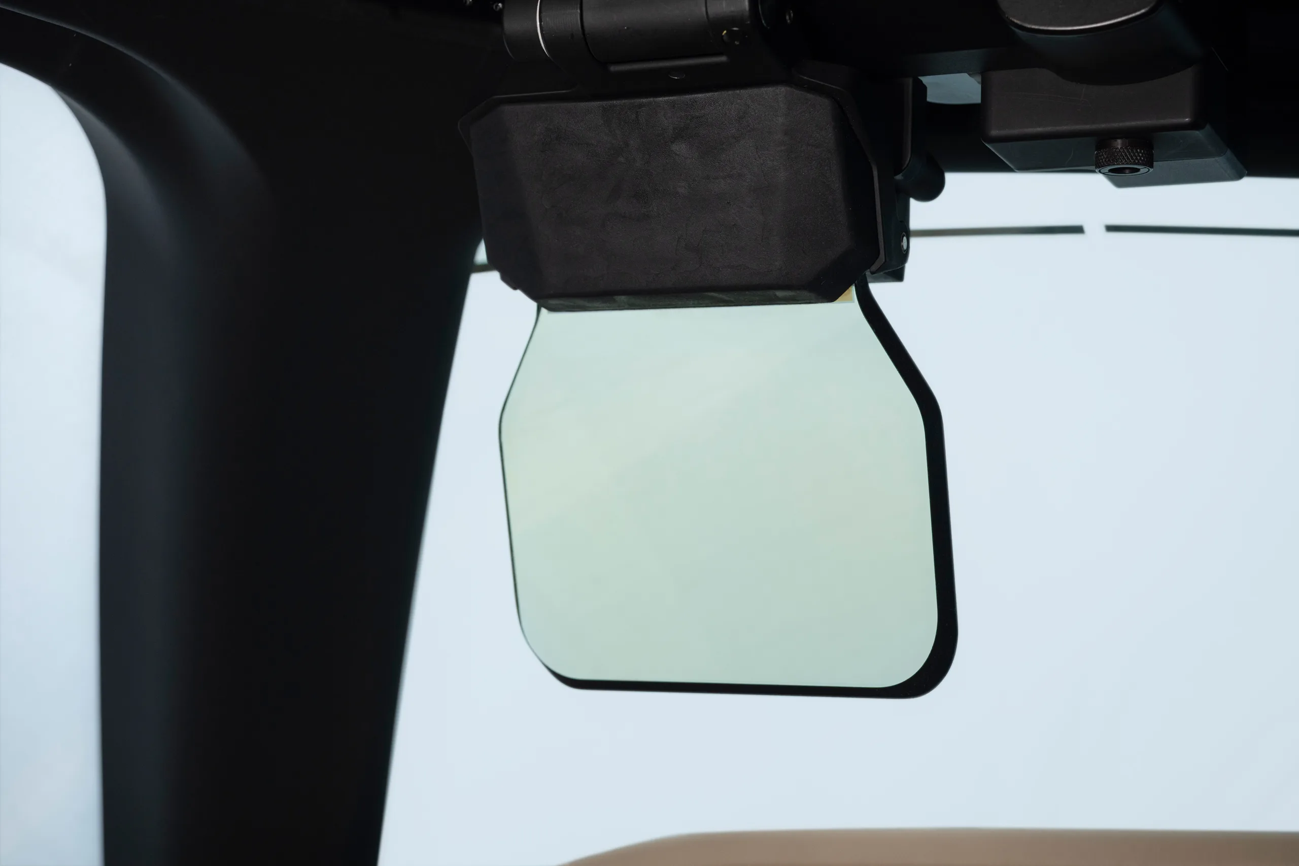 A close-up view of a head-up display (HUD) or sun visor in an aircraft cockpit.