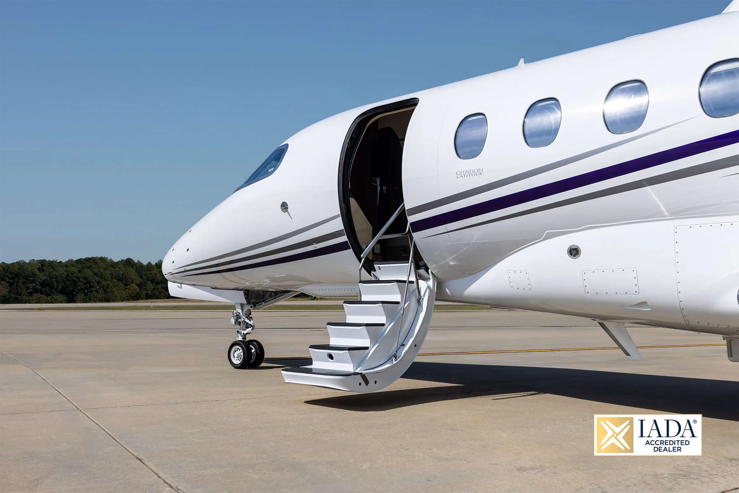 A close-up of the front fuselage of the N464T business jet with its passenger door open and stairs extended.