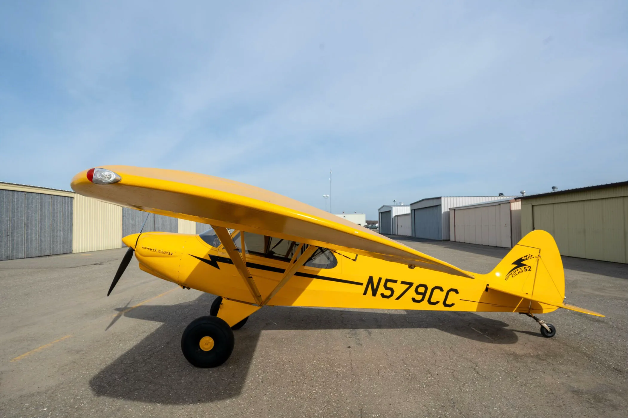 A yellow CubCrafters Sport Cub S2 aircraft with registration N579CC parked on an airfield.