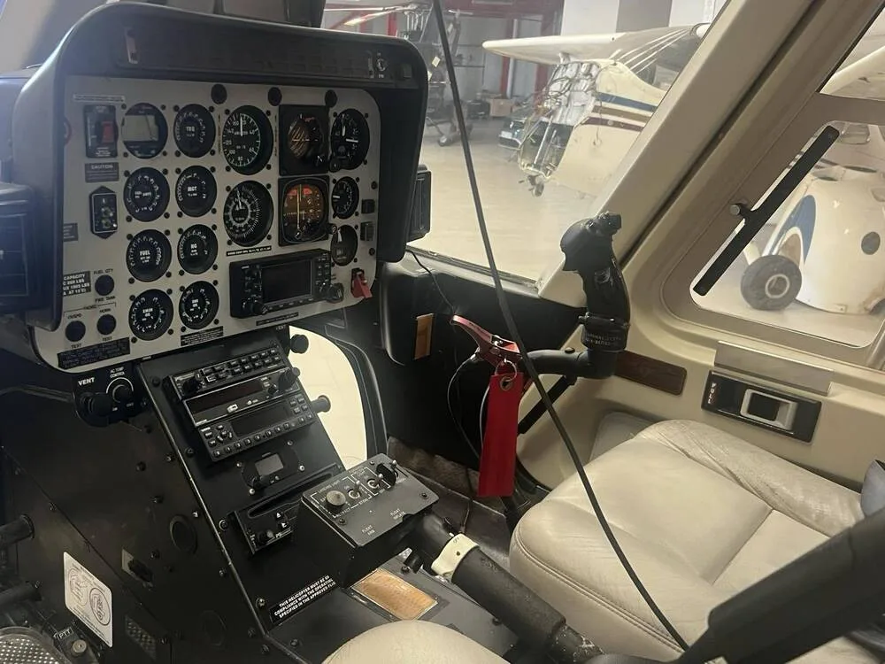 The instrument panel, cyclic, and collective controls in the cockpit of a helicopter.