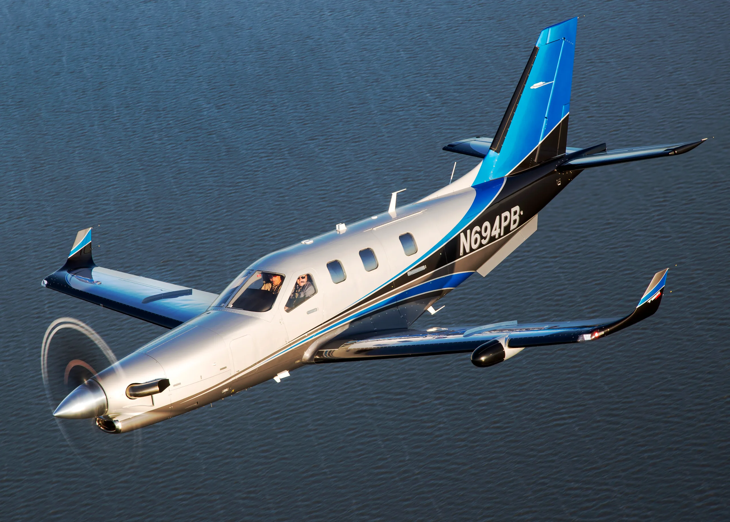 Pilatus PC-12 in flight over water.