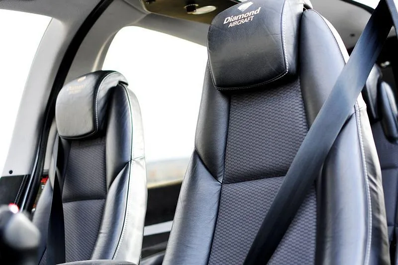 The black leather seats with "Diamond Aircraft" logo on the headrests inside an aircraft cabin.