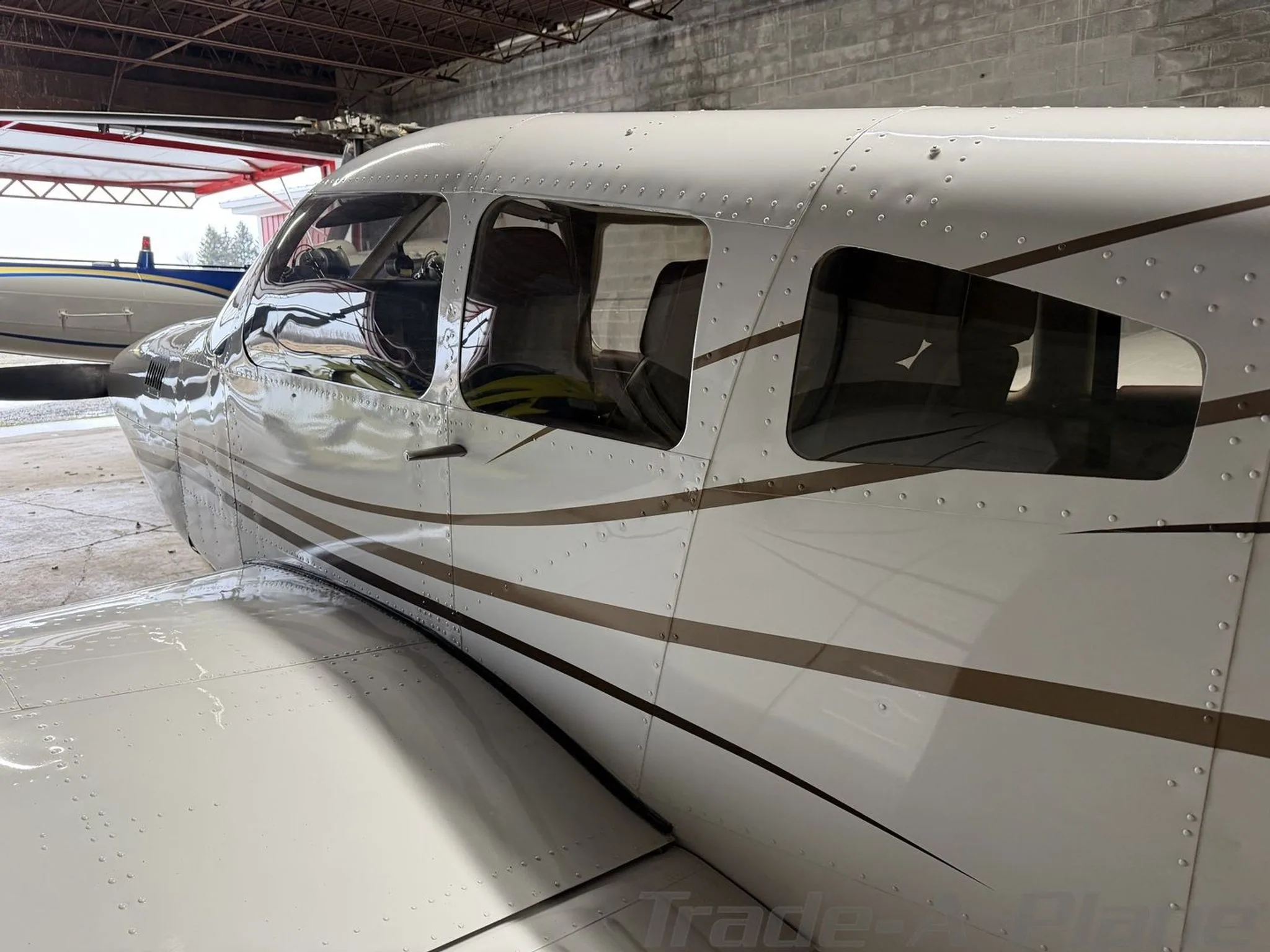 A close-up side view of the cockpit and cabin windows of the white Piper aircraft N41GF.
