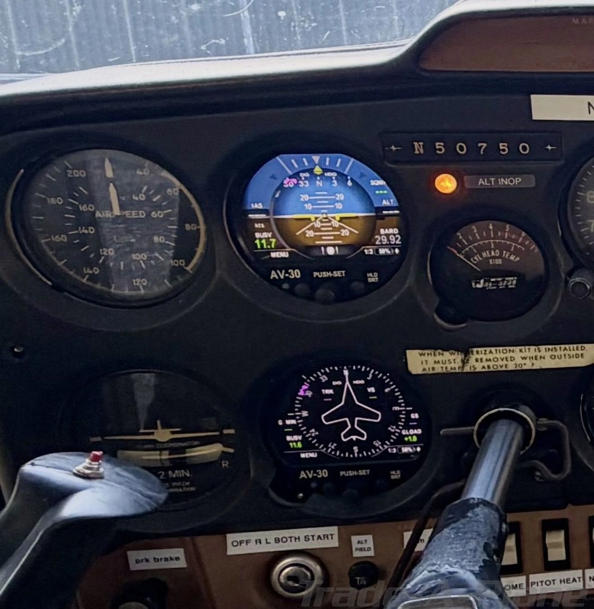 Close-up of a Cessna 172 cockpit instrument panel with analog gauges and two digital AV-30 displays.