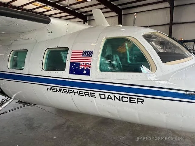 A close-up of the aircraft's fuselage showing 'HEMISPHERE DANCER' text and US/Australian flags near the cockpit windows.