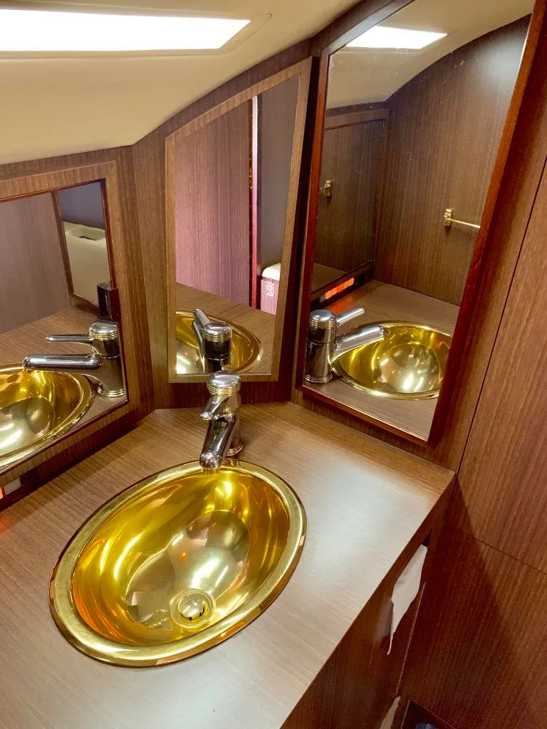 A view of the aircraft's interior with a gold sink and mirror.