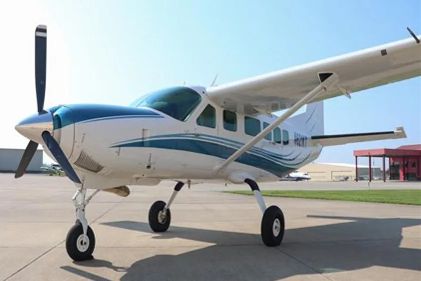 A white and blue single-engine turboprop aircraft (N811MT) is parked on an airport apron.