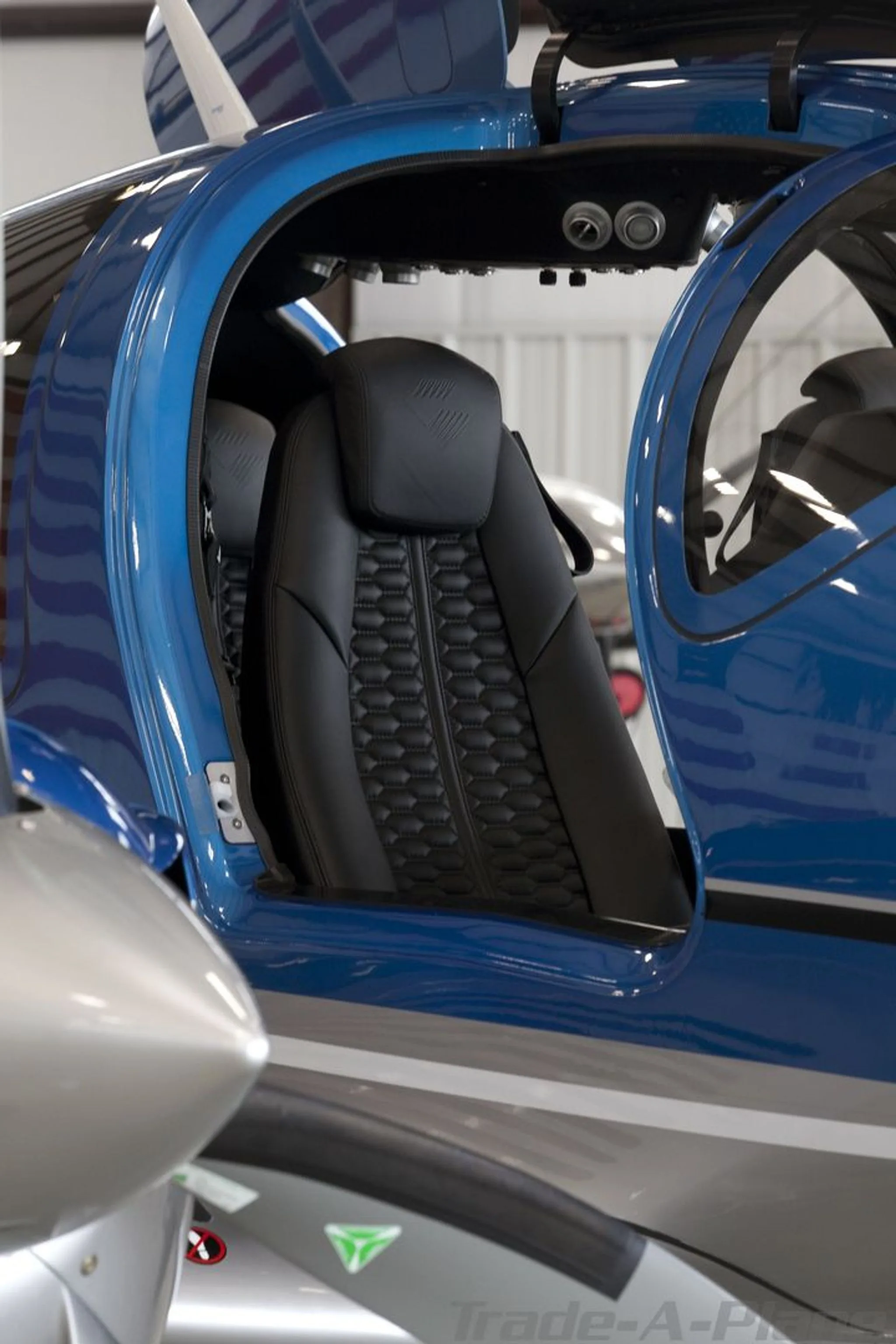 A close-up view of the black quilted leather interior seat of the Diamond DA62 through an open door.