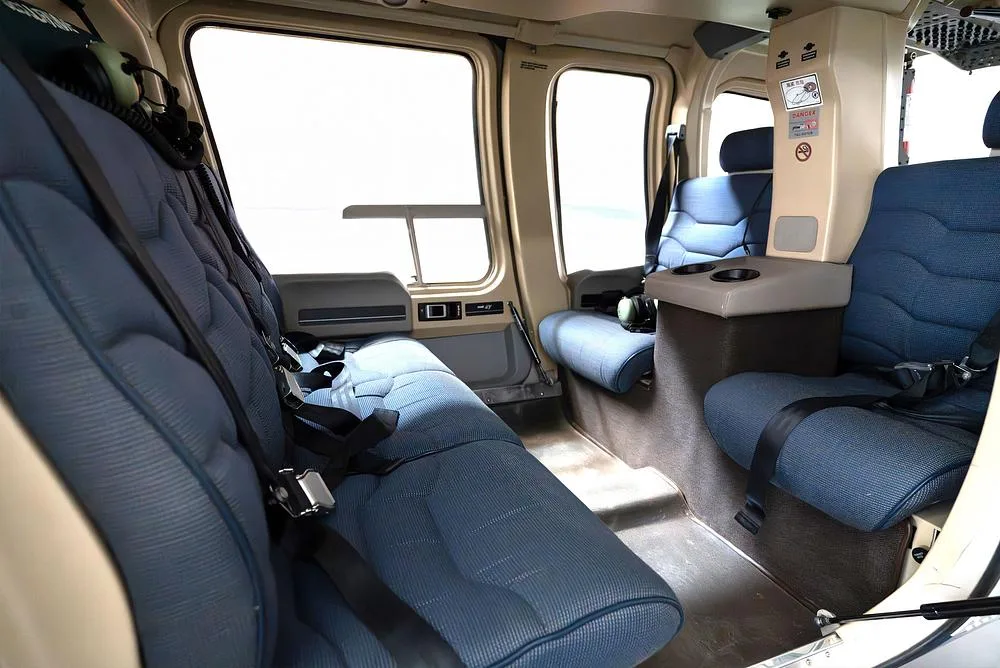 A wider view of the helicopter's interior cabin, showing multiple rows of blue passenger seats.