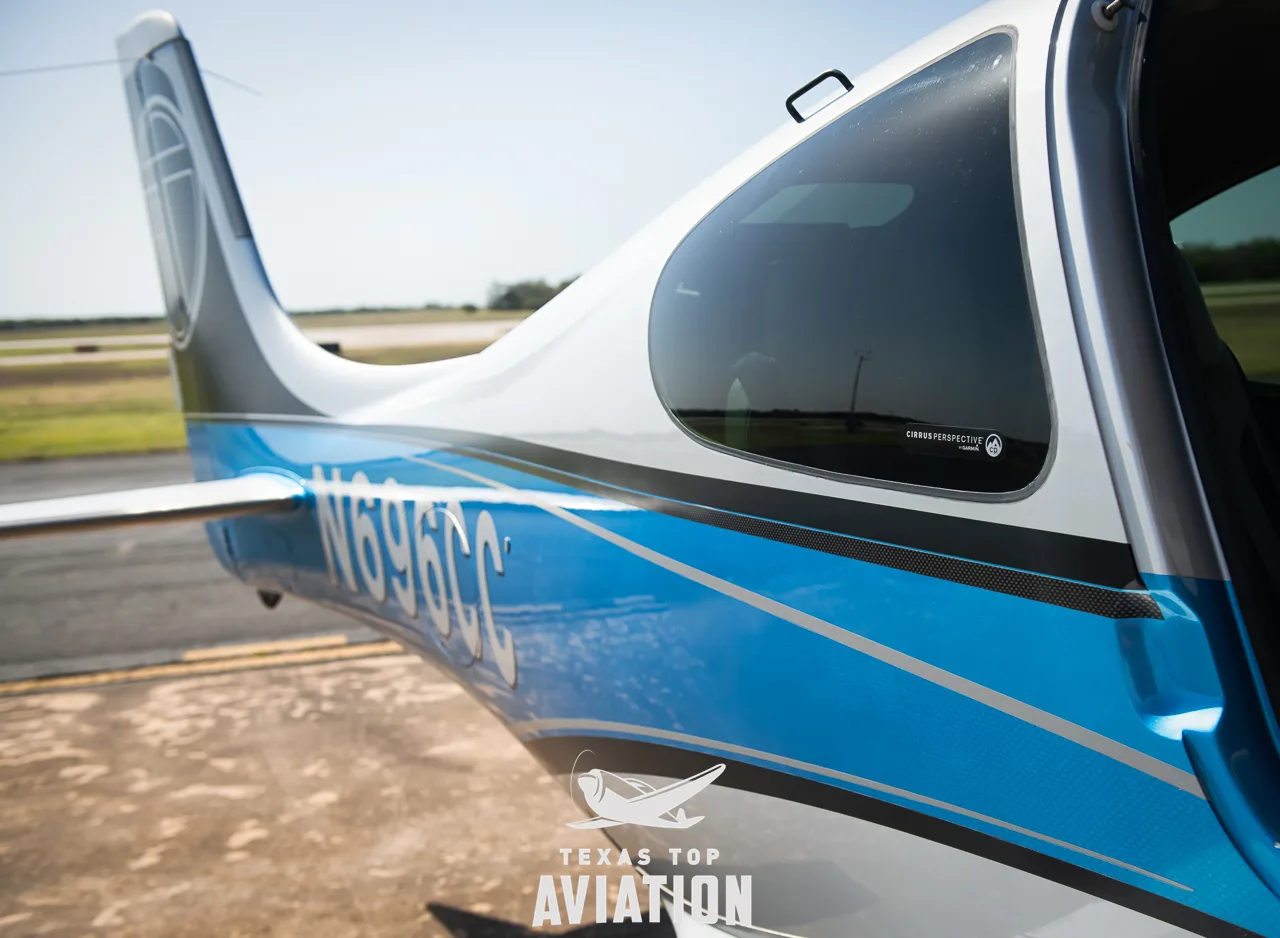 A close-up of the tail section of a Cirrus SR22 aircraft, showing the N-number N696CC and blue and silver paint.