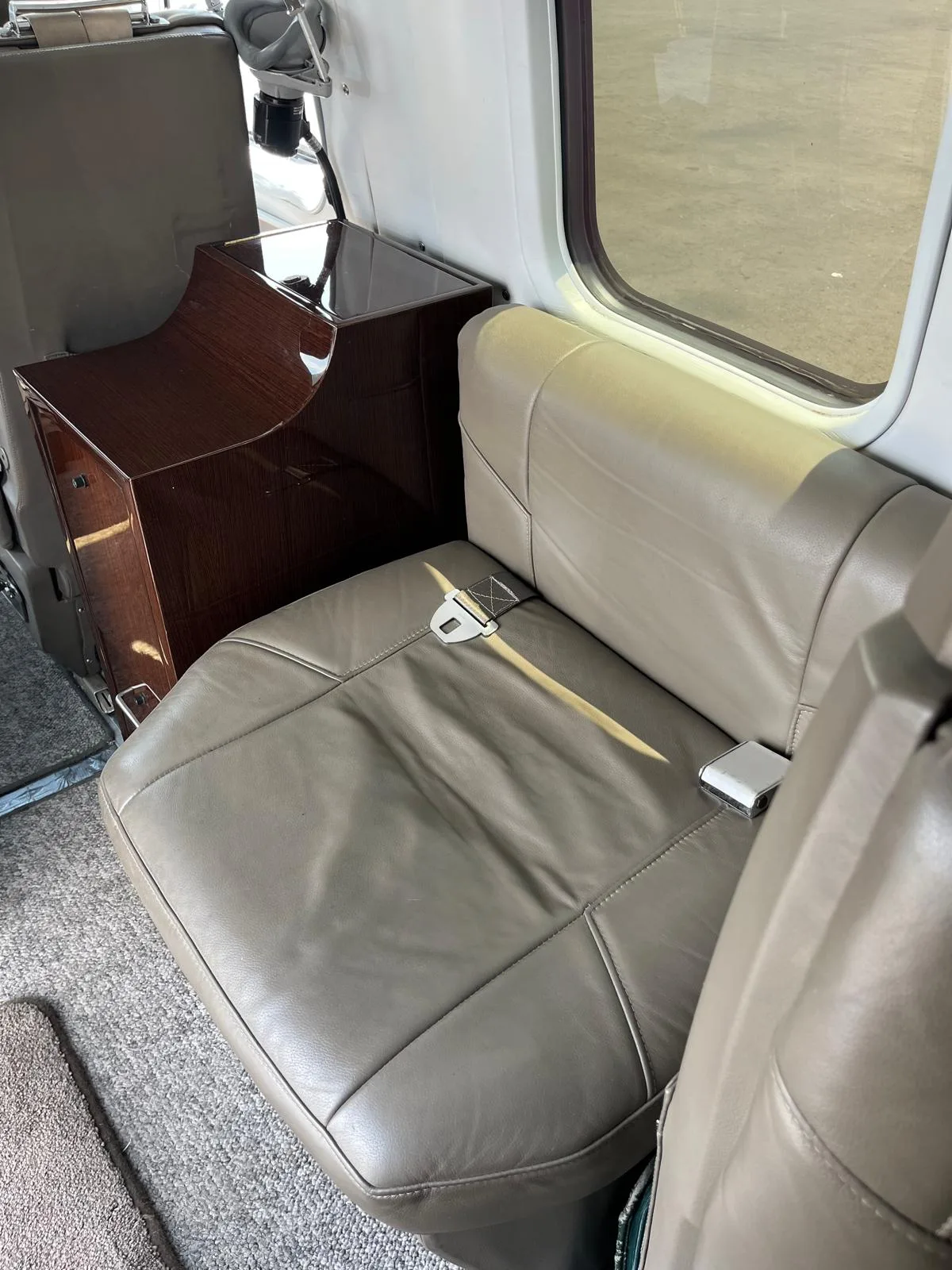 Close-up of the aircraft's interior, showing the leather seat and wooden cabinet.