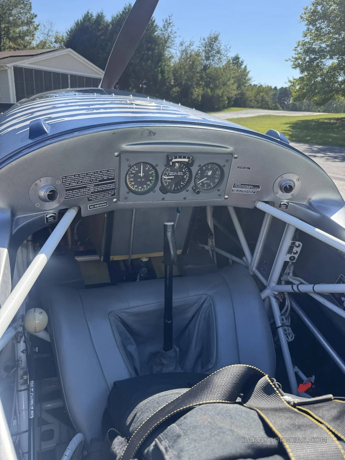 The rear cockpit of an aircraft, showing a grey seat, a control stick, and a small instrument panel above.