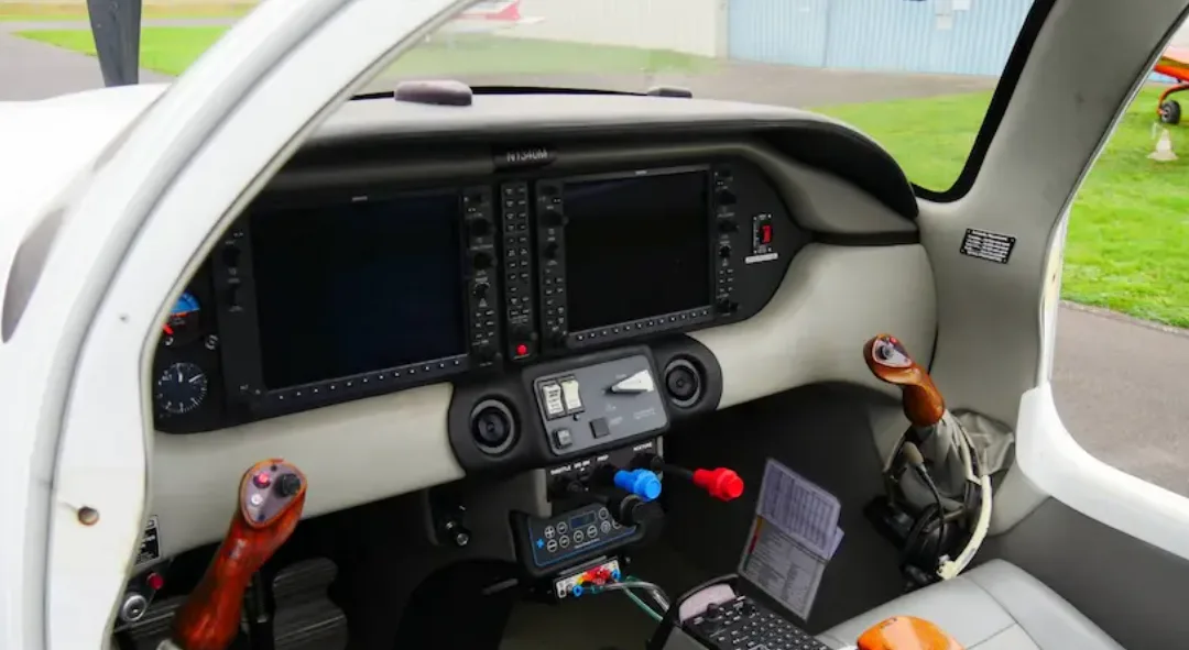 A wide view of the Columbia 400 cockpit with registration N1340M, showing the instrument panel with screens off and side stick controls.
