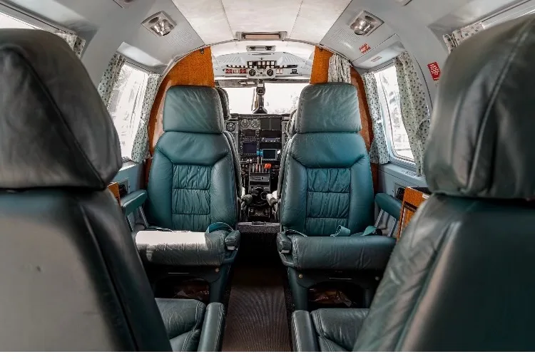 View of the aircraft interior with leather seats and wood trim.