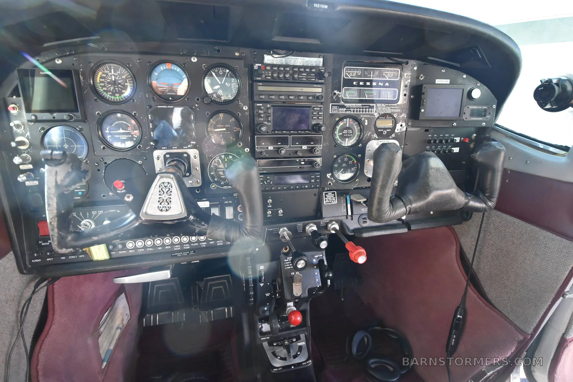 The cockpit of a Cessna aircraft showing the instrument panel with various gauges, radios, and control yokes.