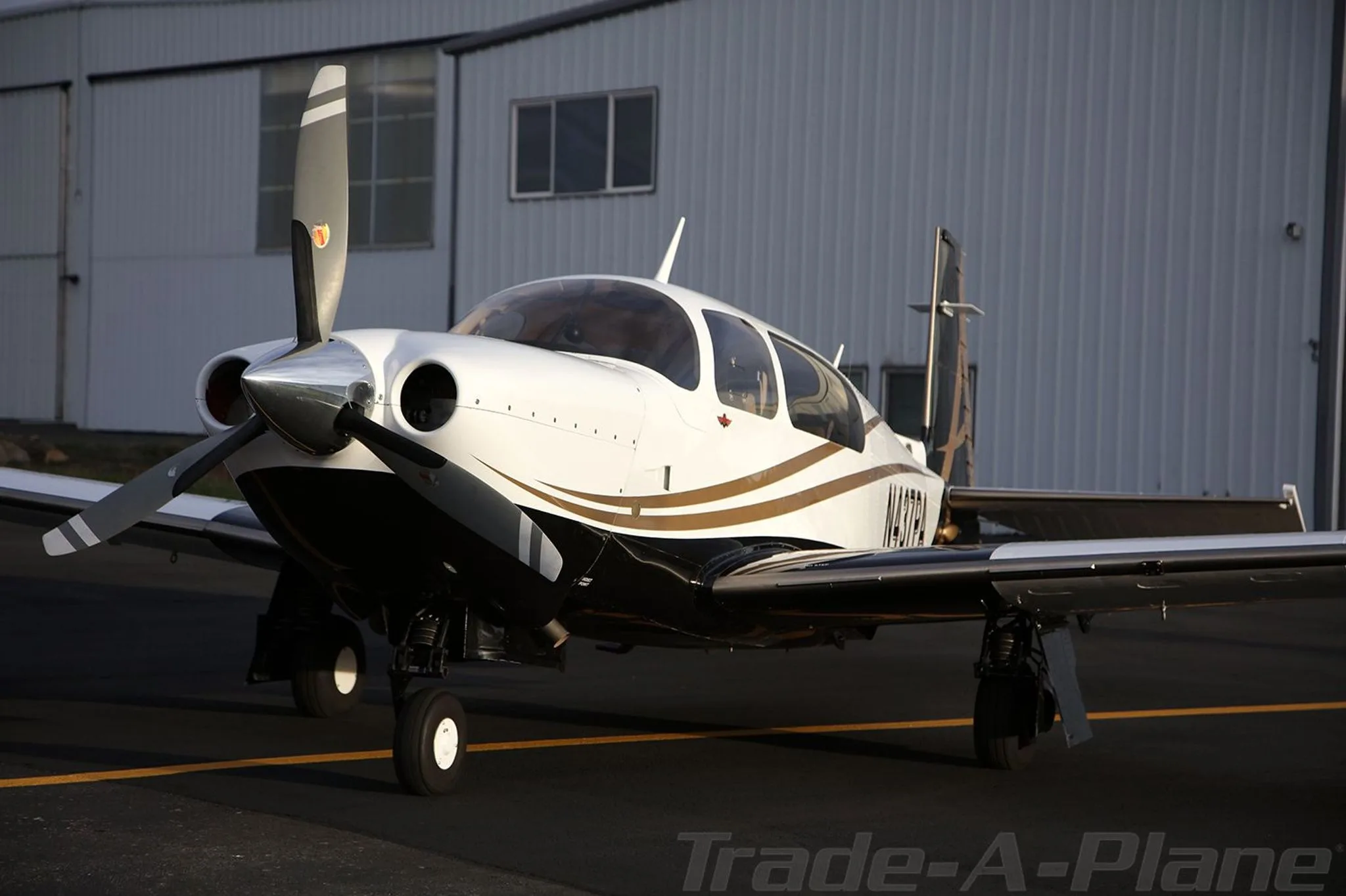 The aircraft positioned in front of a hangar.