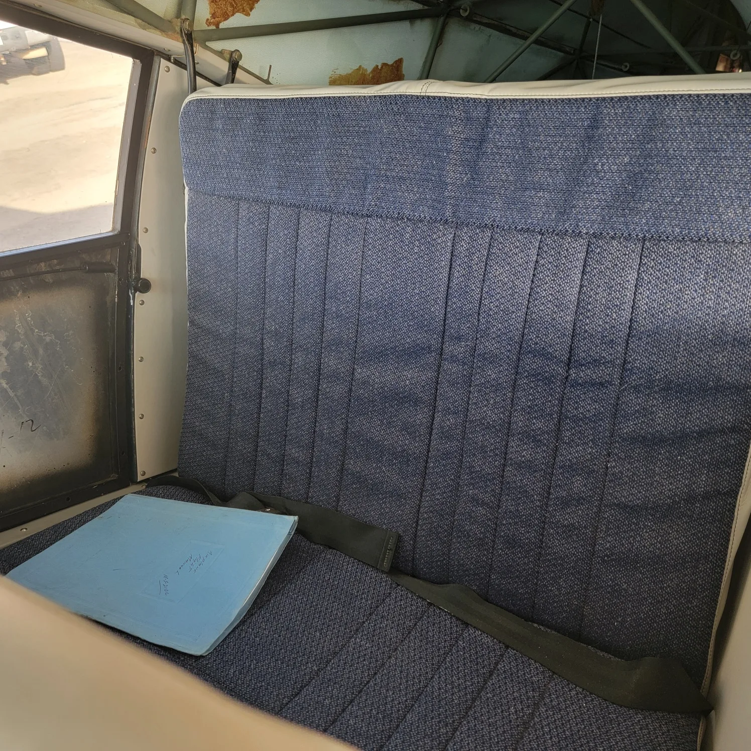 The blue fabric rear bench seat of the Maule aircraft cabin.