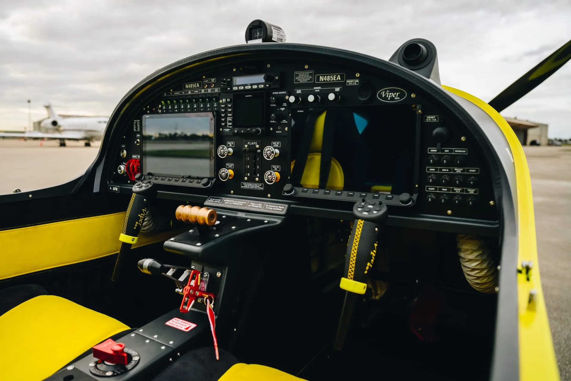 The full cockpit of a yellow and black Viper SD4 aircraft, showing the instrument panel, controls, and seats.