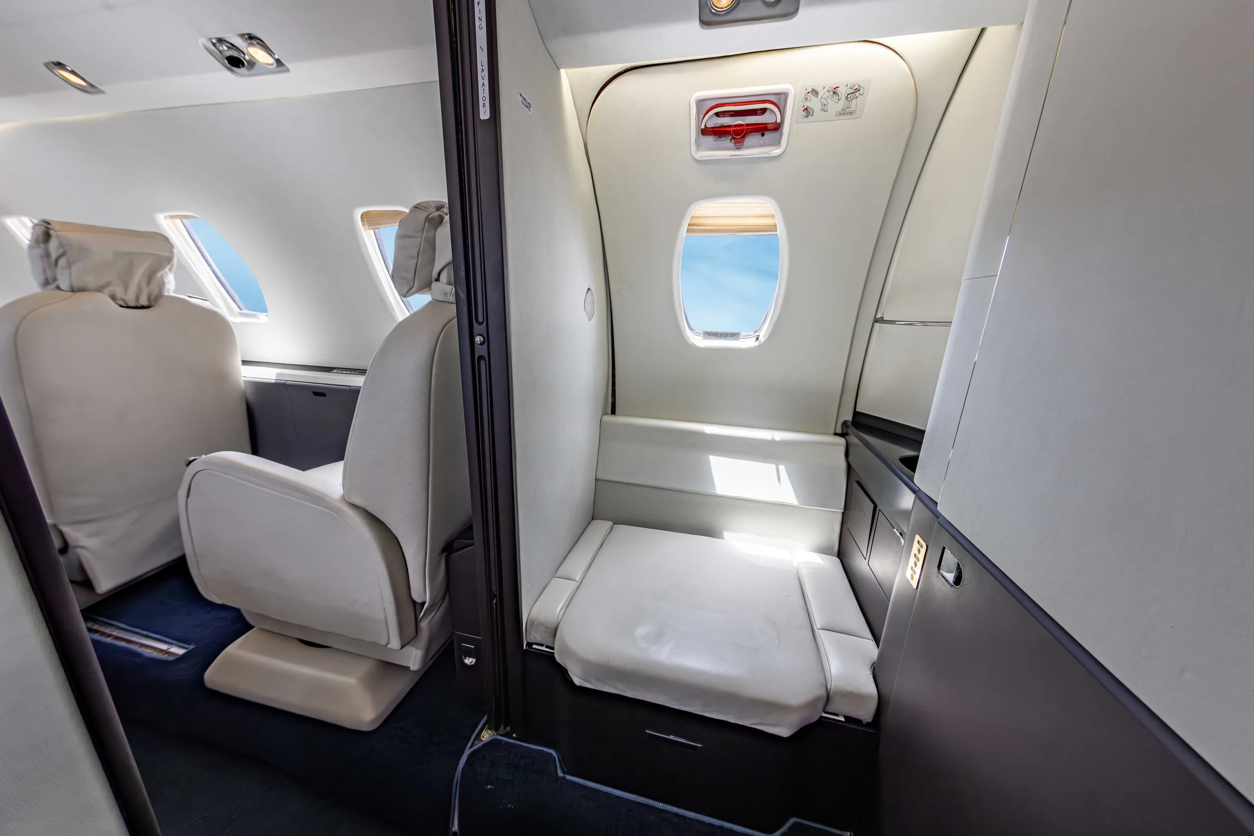 View of the aircraft's interior with a single seat and a small bench seat.