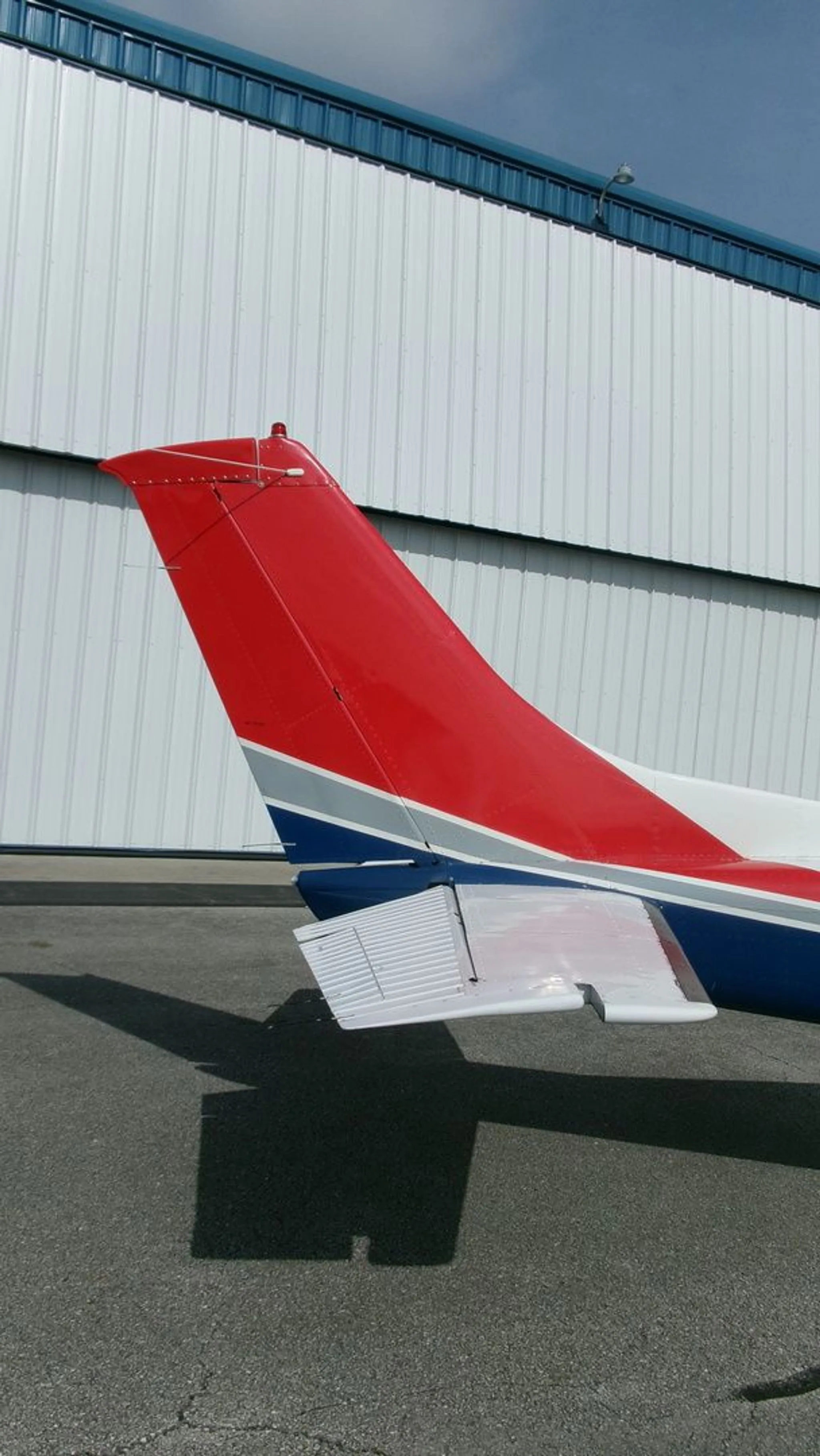 A close-up of the red tail and horizontal stabilizer of the Cessna 182 Skylane.