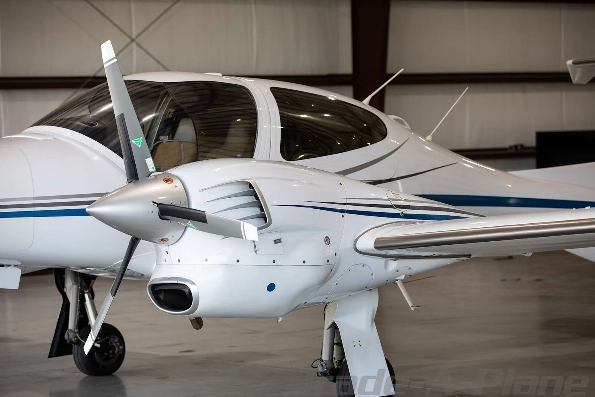 A close-up view of the front-right engine and propeller of a white Diamond DA42-NG aircraft.