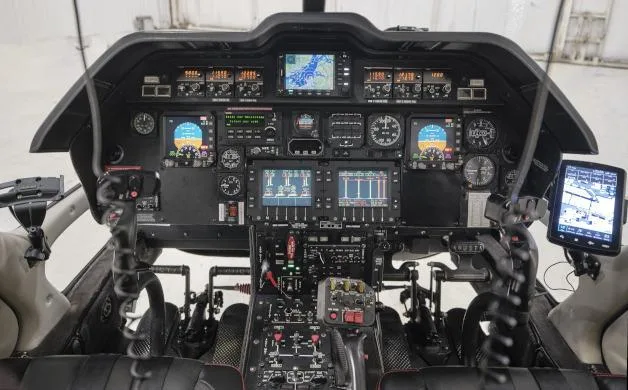 The cockpit of an AgustaWestland AW109 Power helicopter, showing multiple digital displays and controls.