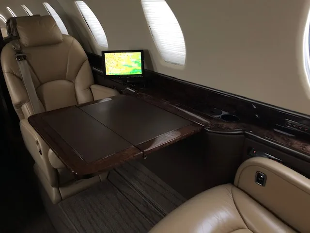 Interior view of the aircraft with leather seats and a table.
