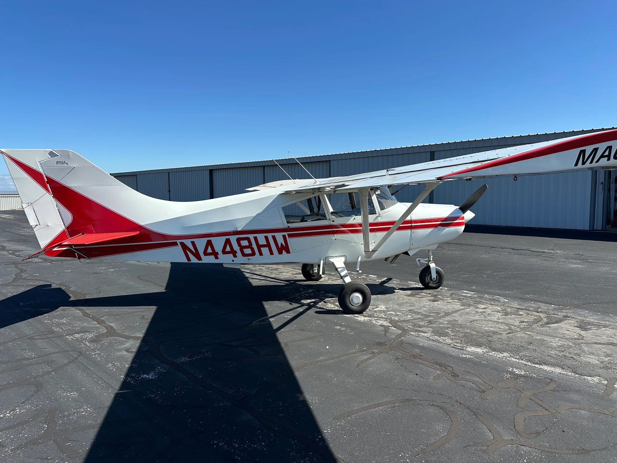A Maute aircraft with red and white paint scheme is parked on the tarmac.