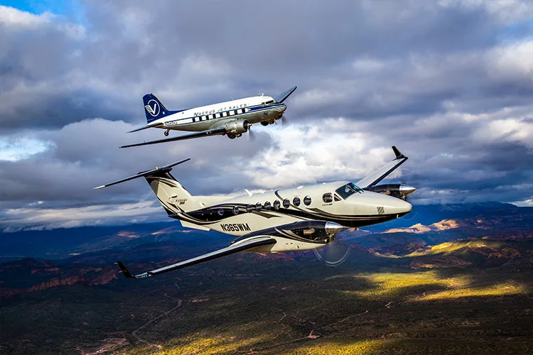 N365WM King Air flying in formation with a vintage aircraft.