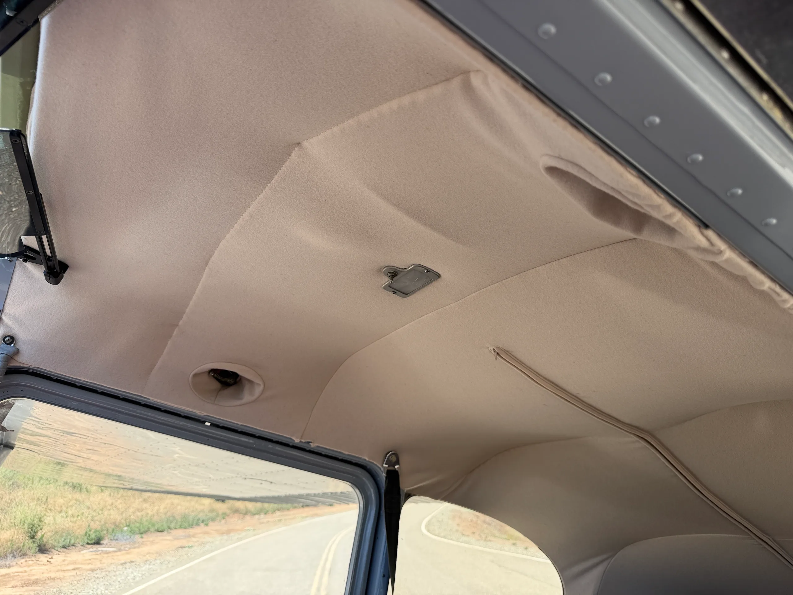 View of the light-colored fabric ceiling of the aircraft cabin.