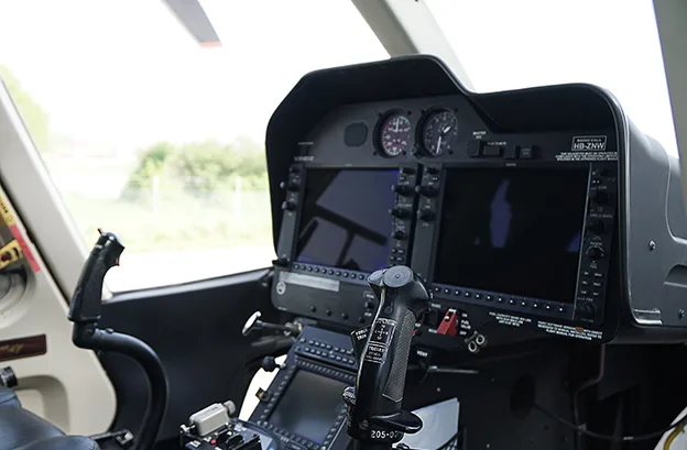 The cockpit of a Bell 505 helicopter with modern avionics.