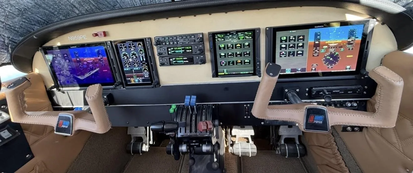 The cockpit of the N959PE aircraft features modern glass panel displays and dual yokes.