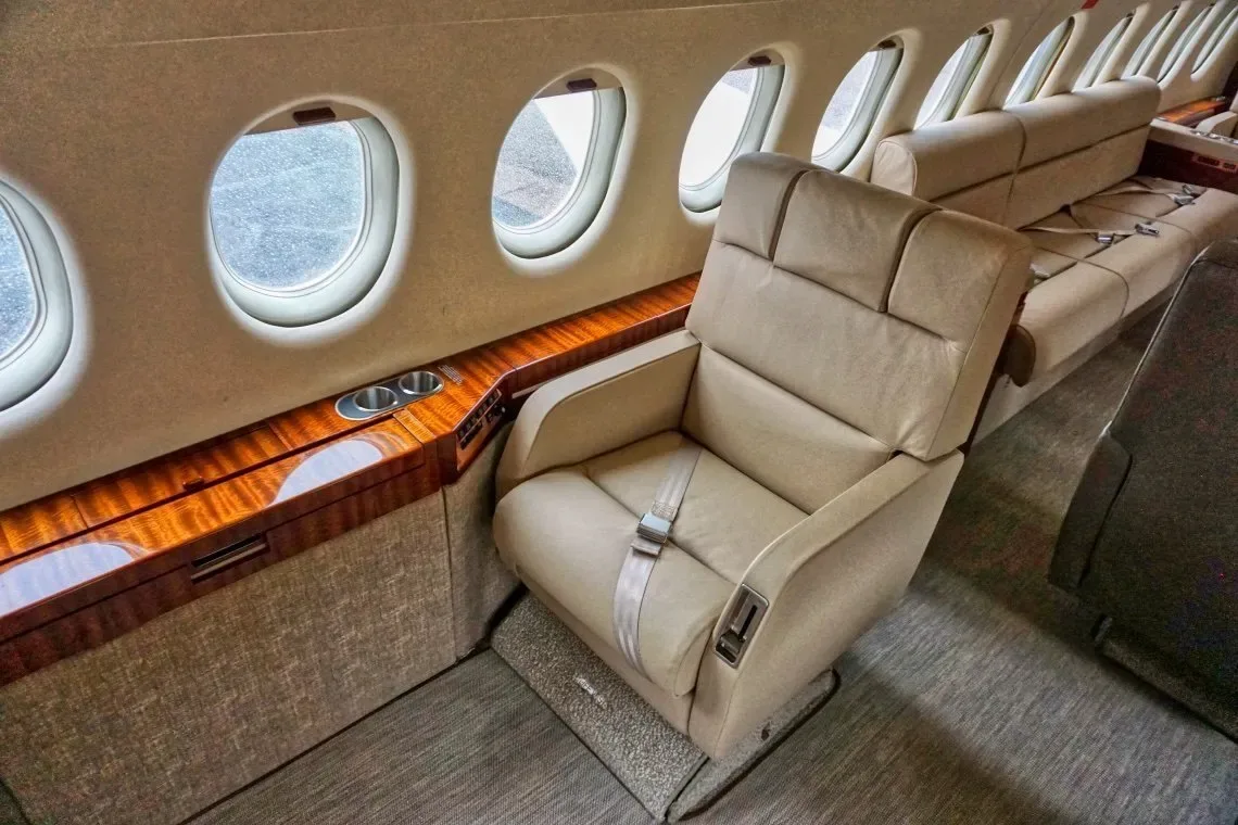 The aircraft's interior features a leather seat and wood trim.