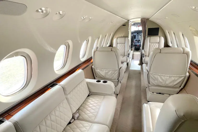 A view of the aircraft's luxurious interior cabin with light-colored quilted leather seating.