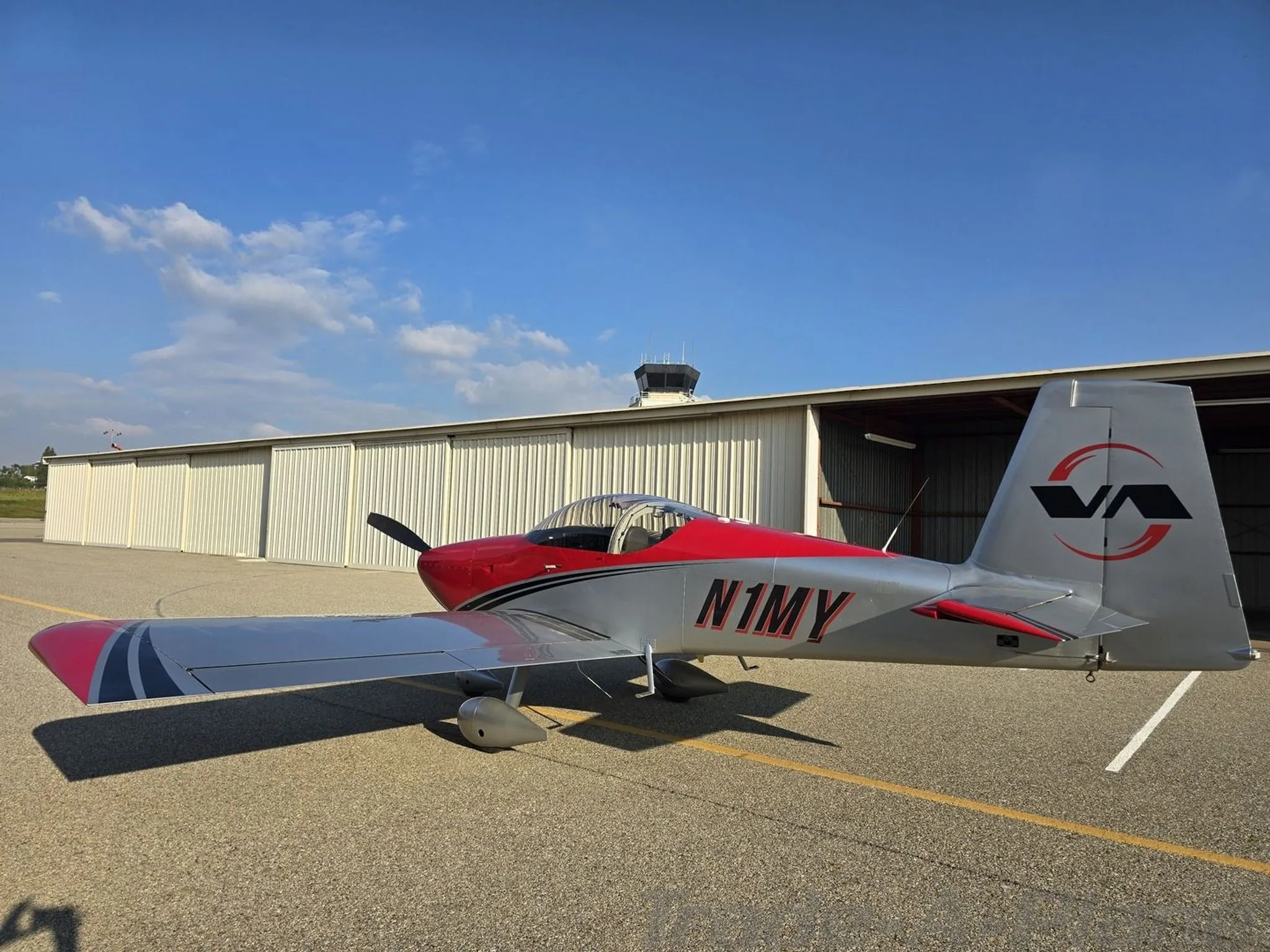 A side view of the VANS RV-7A parked at an airport.