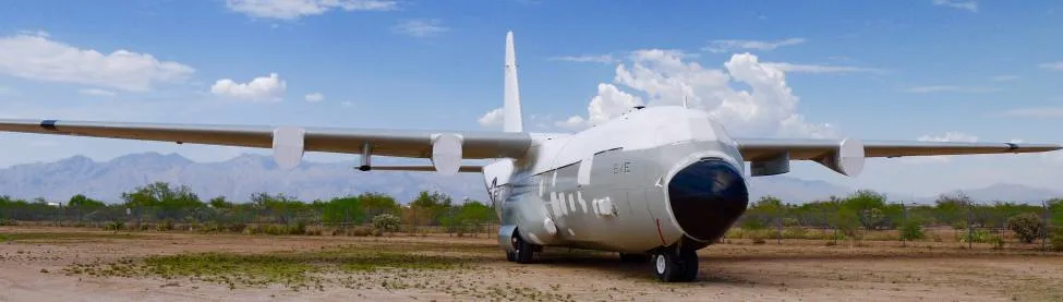 A Lockheed C-130 Hercules parked in a desert setting.