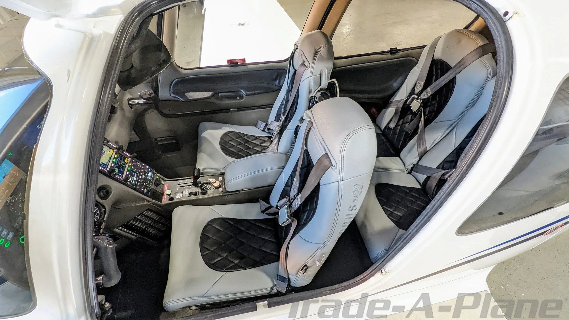 Interior view of the Cirrus SR22 cabin showing light grey and black quilted leather seats.