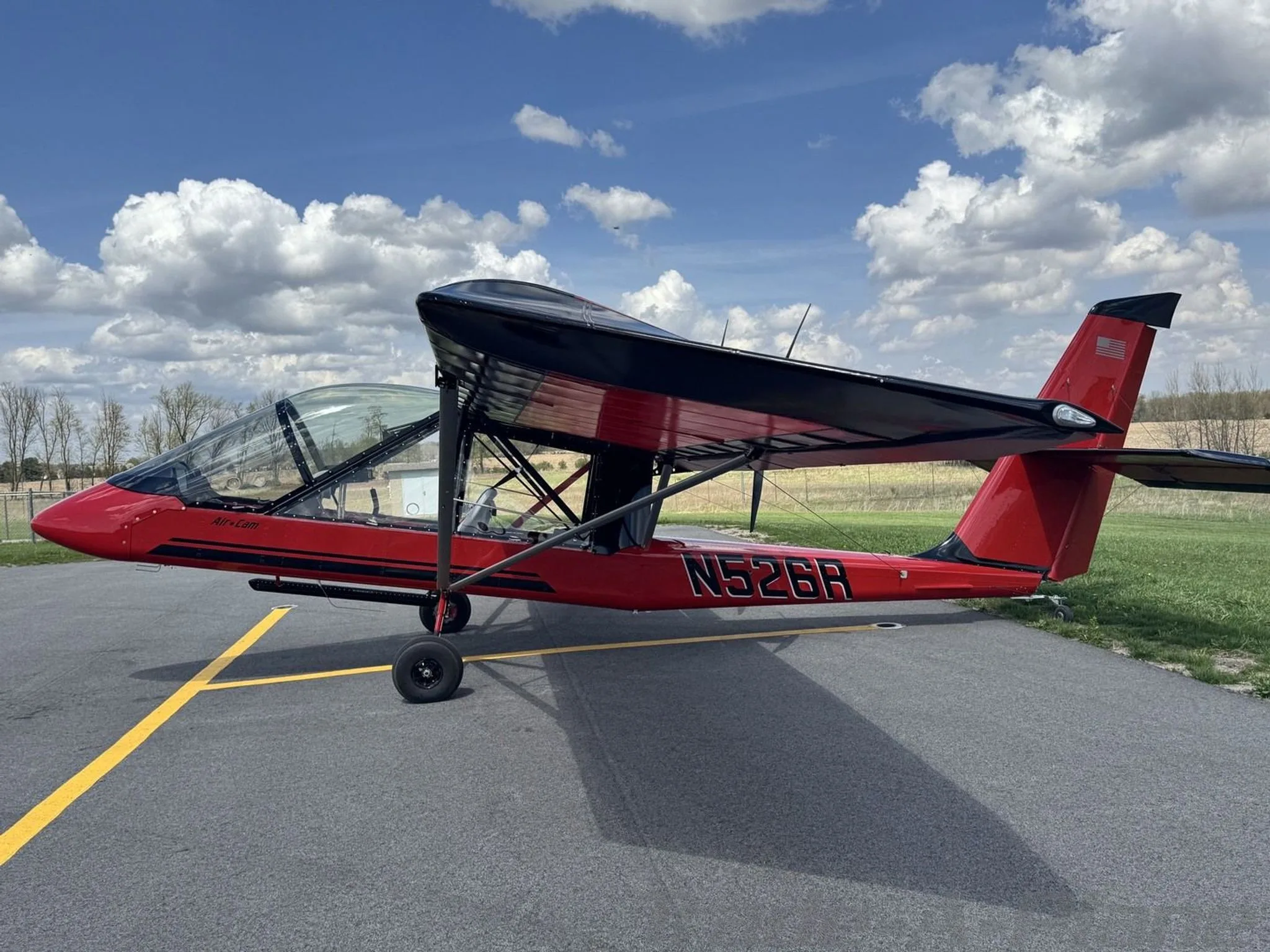 A red and black Air-Cam aircraft with registration N526R is parked on an airfield, viewed from the right side.
