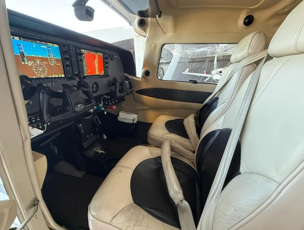 The cockpit and front passenger seats of a Cessna 206 Stationair, with a clear view of the instrument panel.