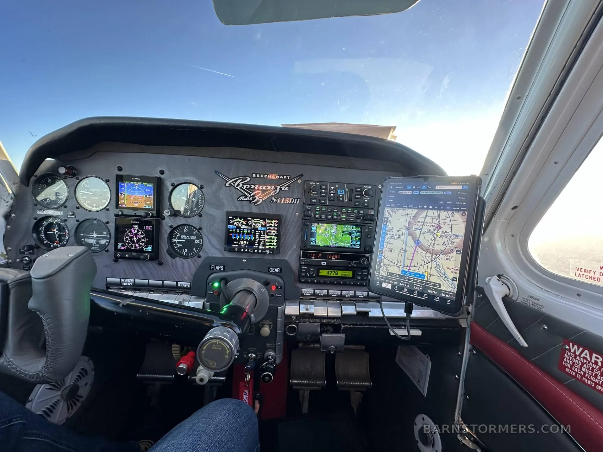 The cockpit of a Beechcraft Bonanza N415DH showing the instrument panel with modern avionics and a mounted tablet.