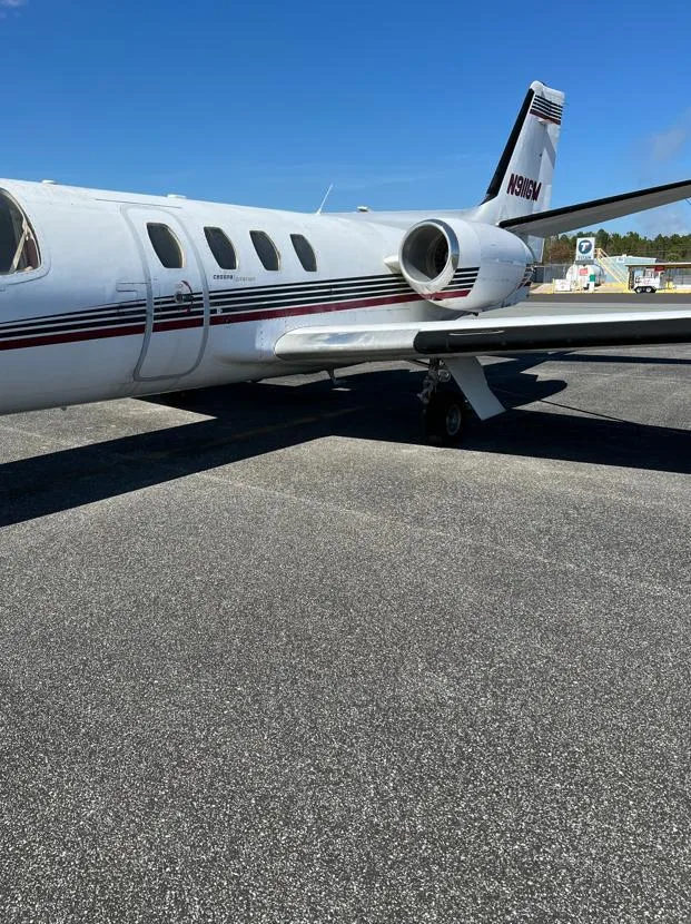 A side view of the rear fuselage and tail of a white Cessna Citation I business jet, showing the registration N911GM.