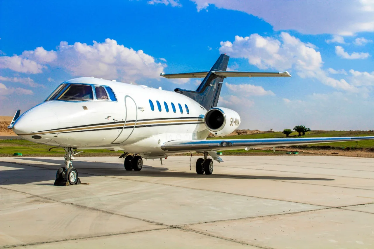 SU-MAN aircraft parked on the tarmac with a white and black paint scheme.