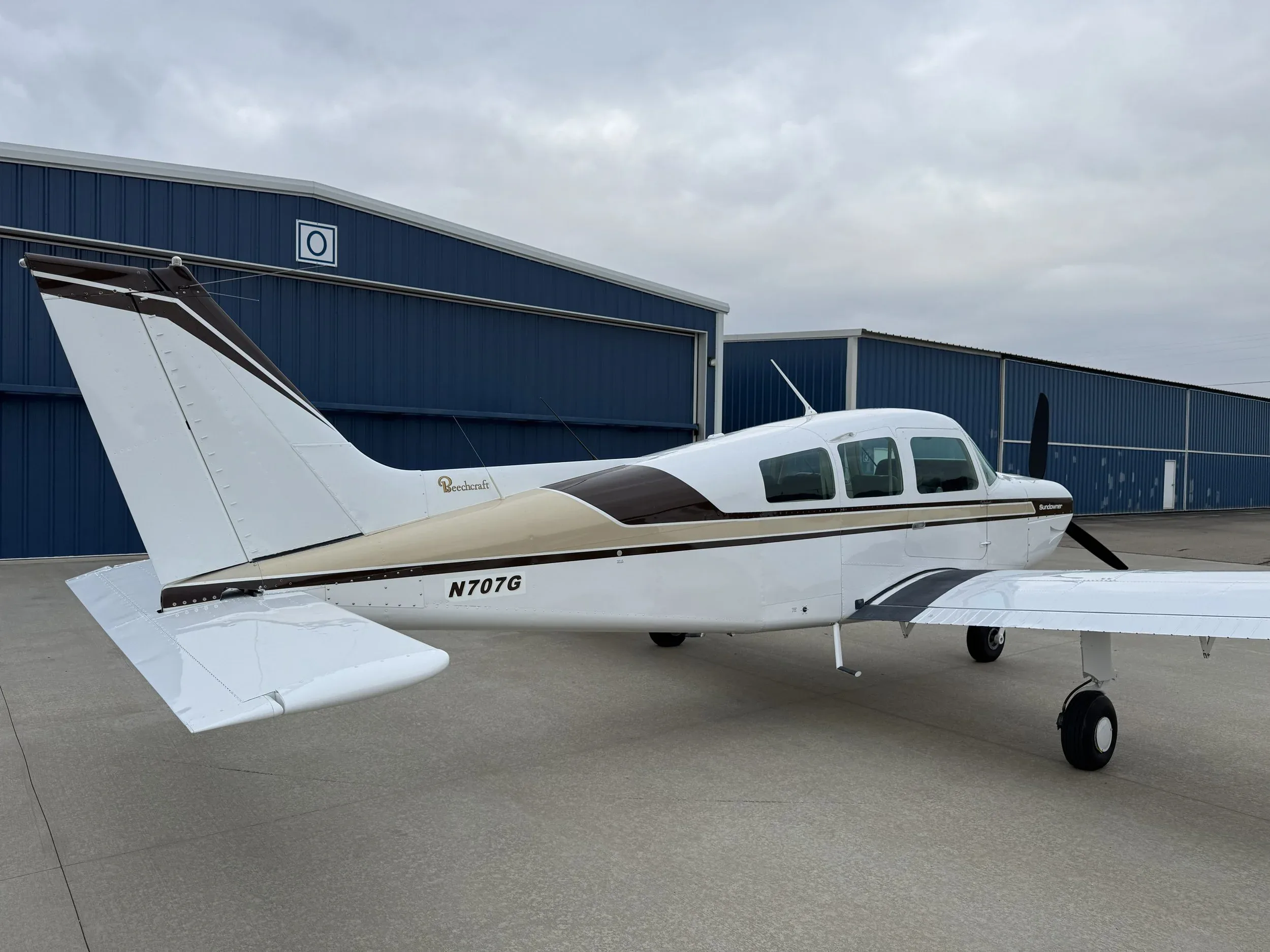 The tail section of a Beechcraft Sundowner aircraft with registration N707G is shown.