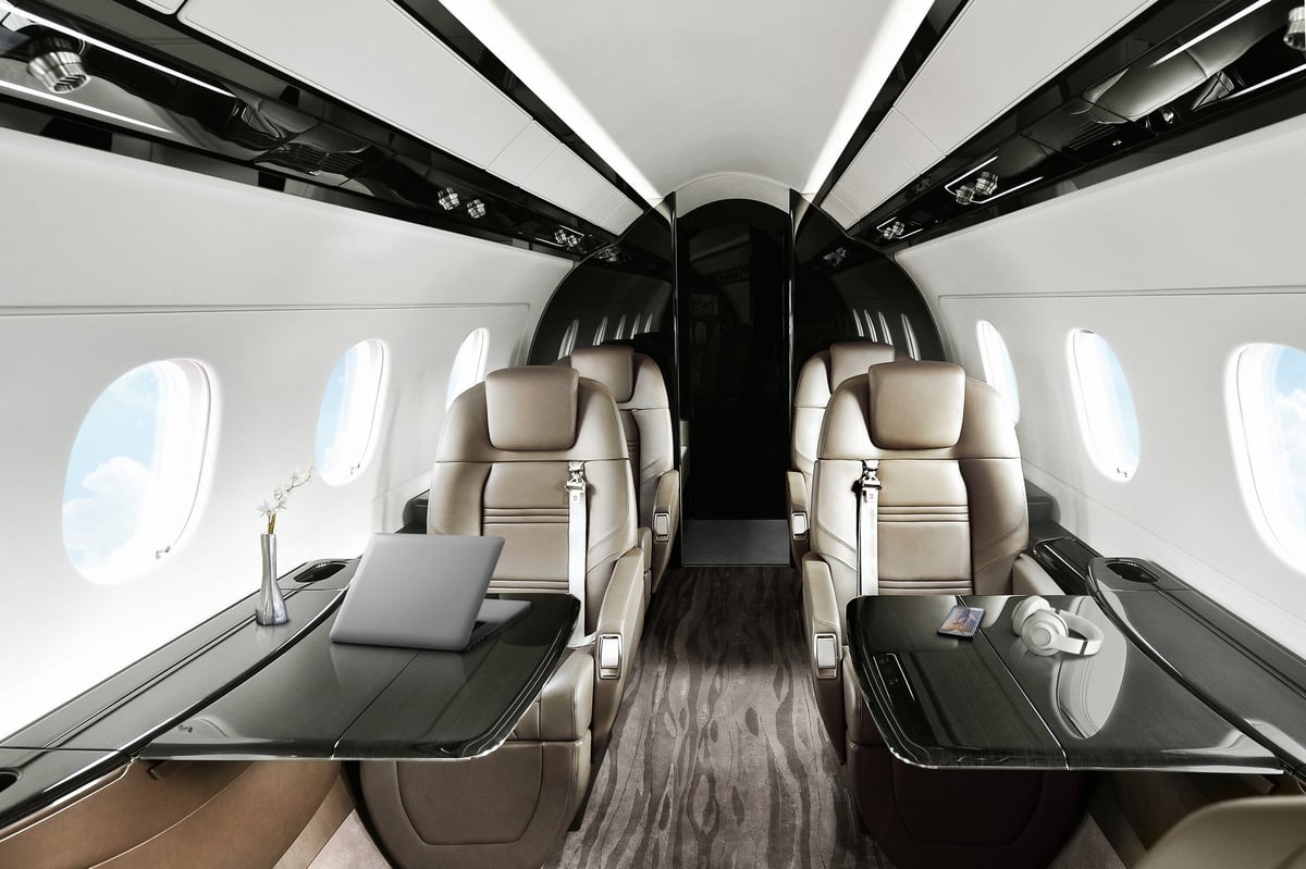 A luxurious aircraft interior with leather seats and dark wood accents.