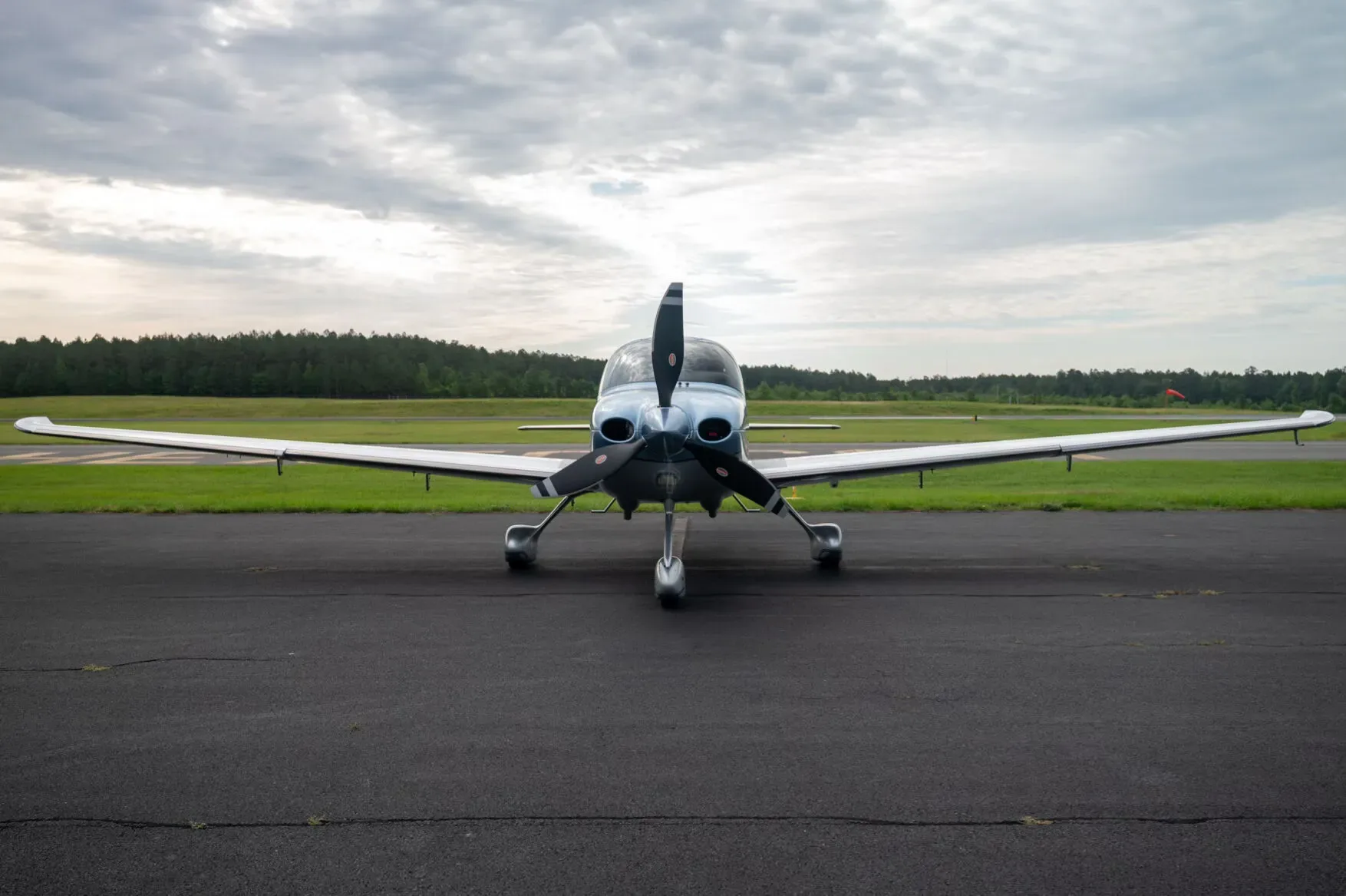 A head-on view of a blue and silver Cirrus SR22 aircraft, N852TW, parked on an asphalt tarmac.