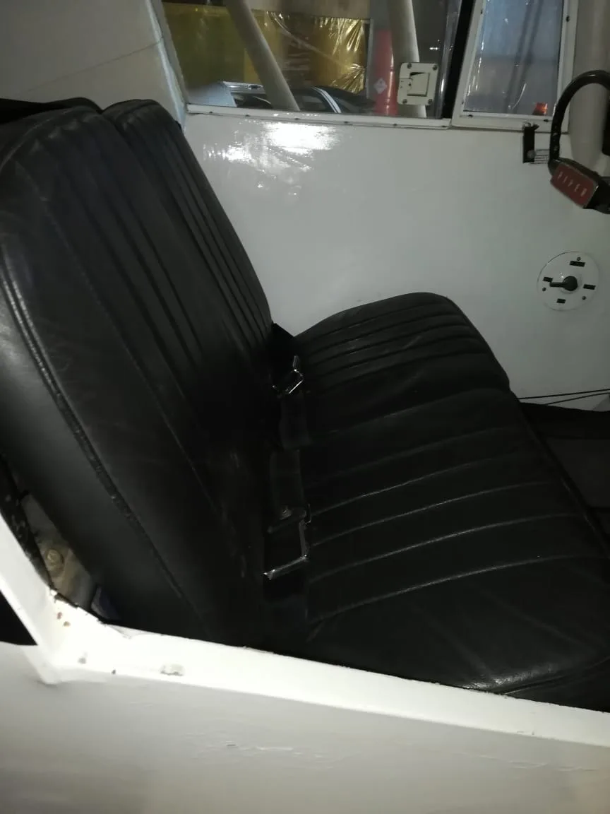 A long black leather bench seat in the interior of a small aircraft cabin.